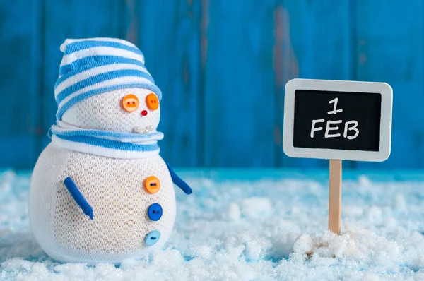 Покажчик 1 лютого і сніговика стоять біля дороговказом. Щасливі Зима листівку — стокове фото