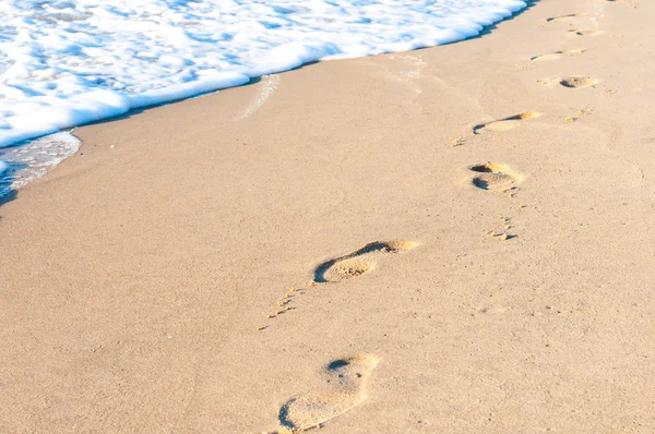 Stopy v písku při západu slunce. Letní cestování koncept — Stock fotografie