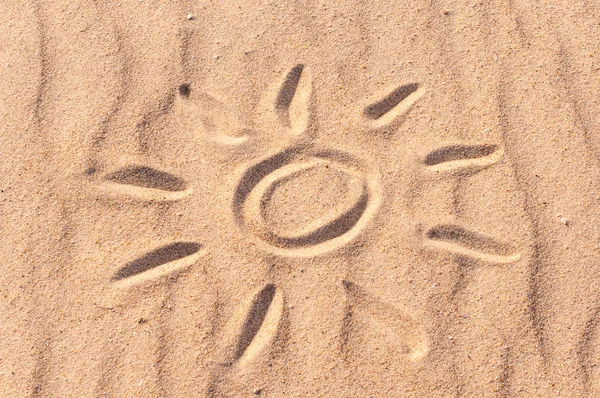 Simple sun drawing in the sand on The beach. Summer travel concept — Stock fotografie