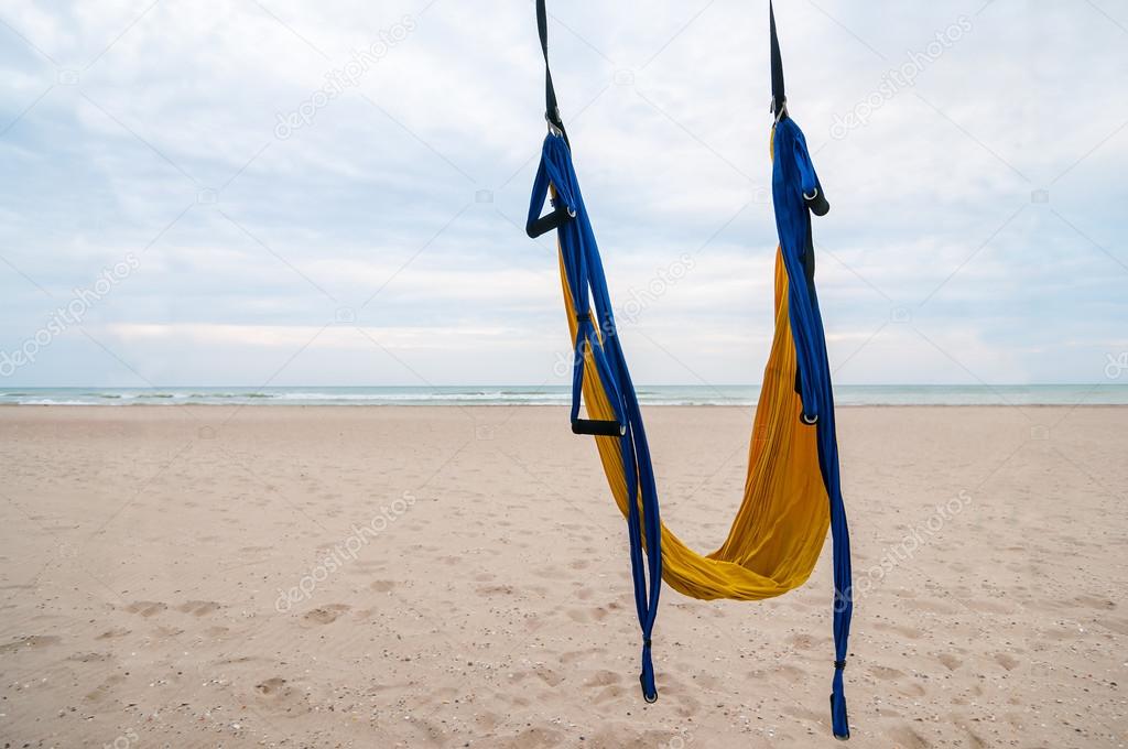 Empty hammock for fly-yoga or antigravity, aerial yoga on tropical beach background