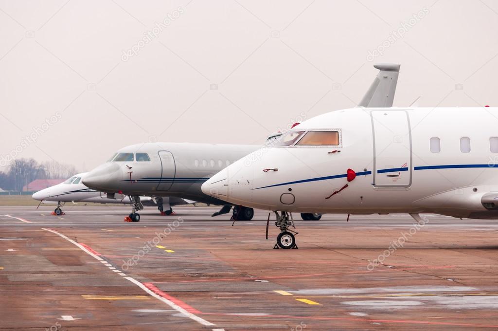 Three Commercial airplane, business jet or aircraft close up on airfield at airport