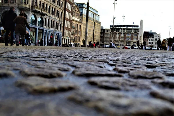 Cobblestone way in Dam Square. Amsterdam street view. Cobblestone ways in Dam Square, Netherlands during overcast weather.