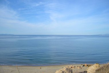 Ufuk çizgisi, Marmara Denizi ve mavi gökyüzü. Sahil, mavi deniz, plaj, kayalık, Mudanya, Bursa, Türkiye 'nin güneşli gününde aynı fotoğrafta sal.