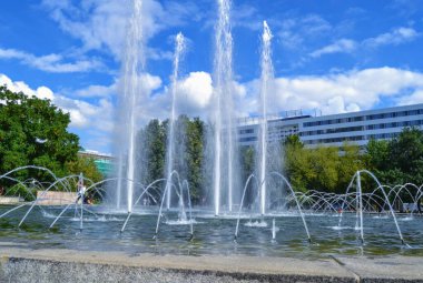 Güneşli bir günde çeşme ve mavi gökyüzü. Chemnitz, Doğu Almanya 'nın merkezindeki kırmızı kulenin yanında çalışan bir çeşme..