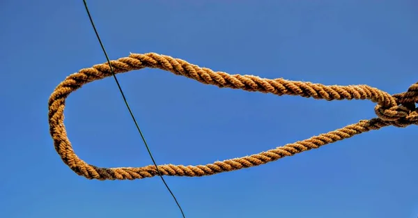 Rope and blue sky background.  A rope tied off as sailor\'s knot.