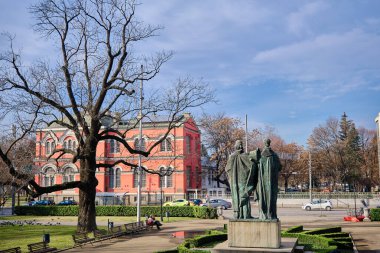 Sts 'in önünde. Cyril ve Methodius Ulusal Kütüphanesi 'nde bir heykel ve üzerinde kurumuş ağaçlar ve caddeler olan küçük bir park var. Bulgaristan. Sofia mı? 06.01.2021.
