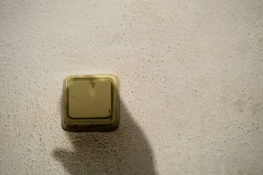 Eski usul antika ve kontak üzerinde el gölgesi olan kirli sarı elektrik teması..