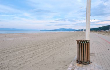 Marmara denizi, bank ve küçük tepe arkaplanı. Muhteşem gökyüzü ve ahşap çöp tenekesi sokak lambası kaldırım kenarında duruyor..
