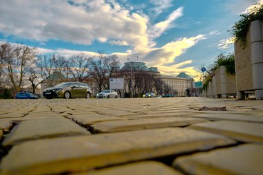 Sofya 'nın merkezi Bulgaristan. Fotoğraf, sarı kaldırım taşlarının alçak açılı, arabalı ve yükselen gökyüzü arkaplanlı hali. Bulgaristan. Sofia mı? 06.01.2021
