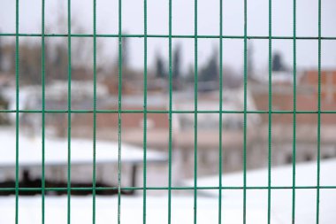 Yağmurlu ve bulutlu havalarda Bursa 'da yeşil çitler ve bulanık ev arka planı.