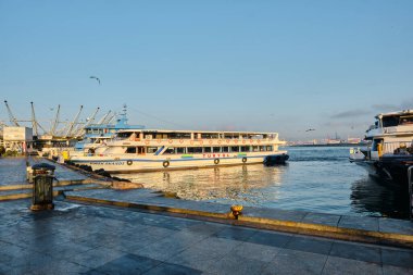 26.02.2021. İstanbul. Hindi. Sabahın erken saatlerinde Bosporus deniz iç taşımacılığı feribotu ve feribotta güneş yansıması. Feribot ve etrafında bir sürü martı.. 