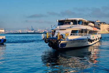 26.02.2021. İstanbul. Hindi. Sabahın erken saatlerinde Bosporus deniz iç taşımacılığı feribotu ve feribotta güneş yansıması. Feribot ve etrafında bir sürü martı.. 