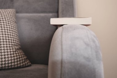 Tek bir eski ve eski moda mor koltuğun ve minimalizm sembolünün en kolları. Eski moda ve retro tarzı tek kişilik koltuklar ve kitap rafının yanında desenli yastık ve yastık.