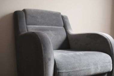 Tek koltuklu renkli fotoğraf ve minimalizm sembolü. Eski moda ve eski tarz tek koltuklu tahta zeminde duruyor ve bacakları ahşap malzemeden. Küçük ve koltukta bir yastık..