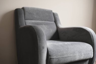 Tek koltuklu renkli fotoğraf ve minimalizm sembolü. Eski moda ve eski tarz tek koltuklu tahta zeminde duruyor ve bacakları ahşap malzemeden. Küçük ve koltukta bir yastık..