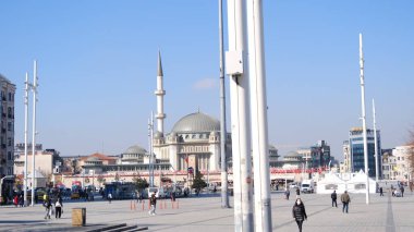 Hindi. İstanbul 04.03.2021 İstanbul, güneşli bir günde Taksim Meydanı 'nın en tanınmış meydanlarından biri. Taksim camii, insanlar turist ve polis geziyor. Meydan her zamanki gibi kalabalık değil..