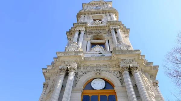 Güneşli bir günde, İstanbul Boğaz Denizi 'nin yanındaki Dolmabahce Sarayı' nın önündeki eski ve eski bir şilte mimarisi ve stil saat kulesi. 03.03.2021 Türkiye.