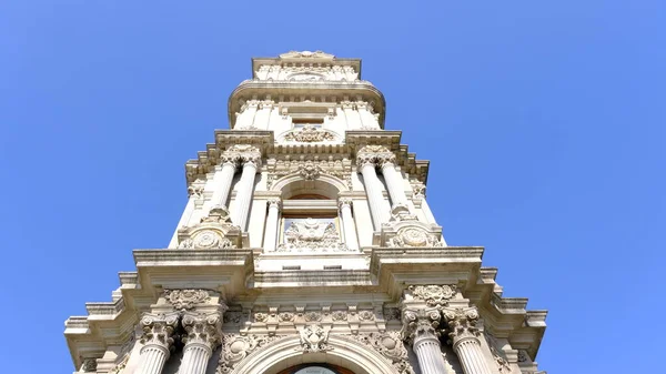 Güneşli bir günde, İstanbul Boğaz Denizi 'nin yanındaki Dolmabahce Sarayı' nın önündeki eski ve eski bir şilte mimarisi ve stil saat kulesi. 03.03.2021 Türkiye.