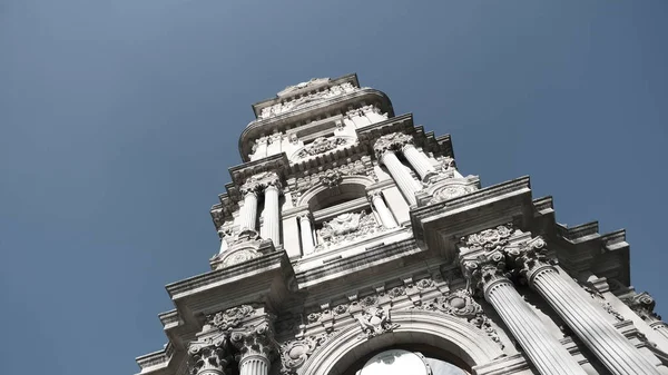 Güneşli bir günde, İstanbul Boğaz Denizi 'nin yanındaki Dolmabahce Sarayı' nın önündeki eski ve eski bir şilte mimarisi ve stil saat kulesi. 03.03.2021 Türkiye.