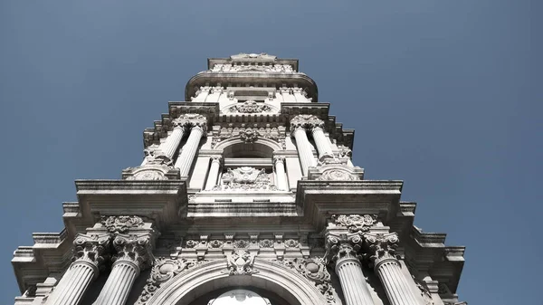 Güneşli bir günde, İstanbul Boğaz Denizi 'nin yanındaki Dolmabahce Sarayı' nın önündeki eski ve eski bir şilte mimarisi ve stil saat kulesi. 03.03.2021 Türkiye.