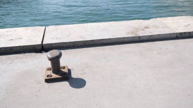 Hindi. İstanbul 04.03.2021. Turkuaz deniz ve gölgesi ile mücadele eden gemi için Kadıköy kıyılarında metal çıkıntısı. Boğaziçi istanbul 'daki feribot ve gemiler için metal bitt bollard