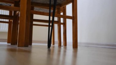 Renkli çoraplar giyen, kot pantolonlu, kameranın önünde yürüyen ve yerden video çeken genç bir adam. Bekar ve eski, eski, antika sandalyeler ve ahşap malzemeden yapılmış bir masada oturuyordum..