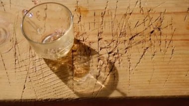 Linden çayı, ahşap tabakta cam demliğe doluyor. Baloncuklar ıhlamur çayını doldururken oluşmuş ve bardağın gölgesi turuncu renge dönüşmüş. Ihlamur yaprağının dolgu parçası düşerken.