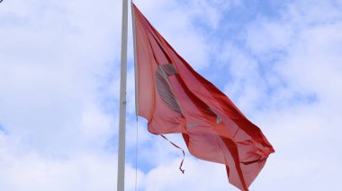 Bulutlu gökyüzü arka planına sahip devasa bir Türk bayrağı. Bayrak yırtıldı