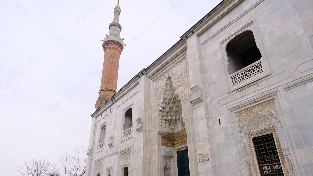 29.03.2021. Bursa Turkey. Corner of the green mosque (Yesil camii) with its minaret extends to cloudy sky established by early stage of ottoman empire