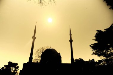 Barok ve İstanbul Boğazı yakınlarındaki eski Dolmabahce mimari camii. Sabahları bir dolmabahçe camiinin silueti ve güneş ışığı ve güneşli bir gün. 03.03.2021 İstanbul Türkiye.