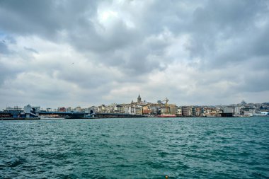 04.03.2021 İstanbul hindisi. İstanbul 'da bulutlu ve yağmurlu bir günde Eminonu ilçesinden çekilen fotoğraf Altın Boynuz (haliç) fotoğrafı. Dairelerin ve galata kulesinin mimari detayları. 