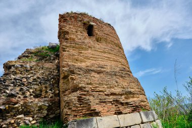 Nicaea 'daki eski ve antik şehir duvarı (iznik Bursa) Bizans tarafından yıkıntı ve taş mezarlarla kurulmuş, güneşli bir günde yeşil çimenler ve sarı çiçekler ve büyük çimenler boyunca uzanan küçük patika..