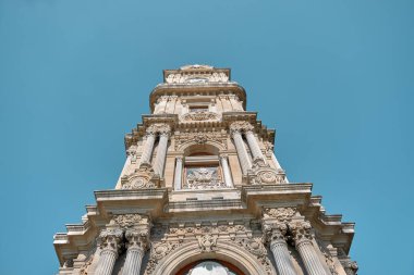 Güneşli bir günde İstanbul 'daki Dolmabahce Sarayı' nın önündeki eski ve antik Osmanlı mimarisi ve stil saat kulesi. 03.03.2021 İstanbul Türkiye.