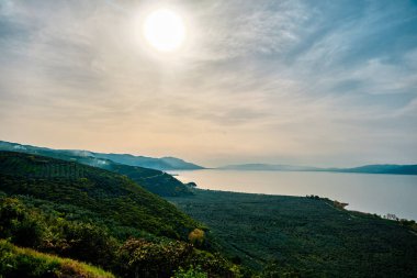 Yeşil bitkiler, orman ve yol ve yol işaretleriyle Nicea Iznik Gölü (iznik golu). Ünlü ve büyük göl manzaralı. Gün batımında ve güneş