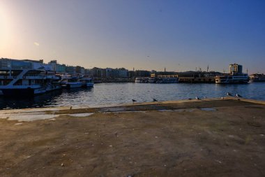 Türkiye istanbul 04.03.2021. İstanbul Kadıköy 'de gündoğumu. Beton liman ve yaya feribot arka planında çok sayıda martı var..