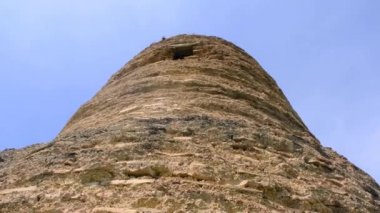 Eski ve harabe şehir duvarları İznik 'te terk edilmiş ve kahverengi şehir duvarları taştan ve kırmızı tuğlalardan yapılmış yeşil çimlerin etrafında sarı ve mor renkli çiçekler var..