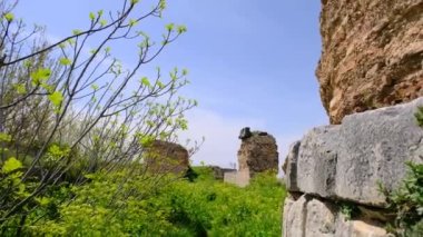 Yeşil çimlerin etrafındaki sarı ve mor renkli çiçekler ve eski ve harabelerle birlikte İznik 'teki eski şehir duvarları terk edilmiş ve kahverengileşmiş şehir duvarları taştan ve kırmızı tuğlalardan yapılmıştır. 
