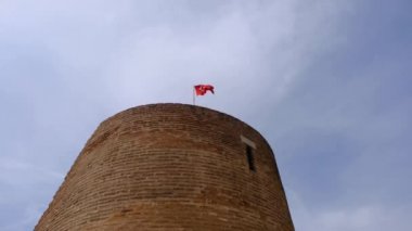 Şatonun tepesinde dalgalanan Türk bayrağı ve kırmızı tuğlalardan oluşan kale, İznik 'in (Nicaea) Bursa kentinin duvarlarını gökyüzü ile harap ediyor. Eski Osmanlı şehri giriş kapısı