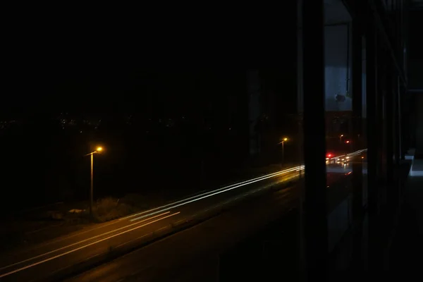 Night photo with long exposure with street lamp and cars front and rear lamps reaminings on the photo.