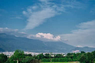 Bursa ve ulu dağlarındaki yeşil kavak ağaçları (uludag) panoramik manzara ve bulutlar ve birçok sokak ve elektrik direğine sahip küçük tarımsal alan.