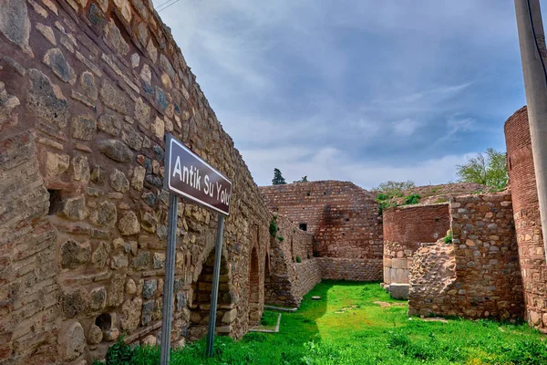 Ancient city walls and water ways in iznik made of red bricks wall covered by and grass with blue sky background established by byzantine empire. Translation is \