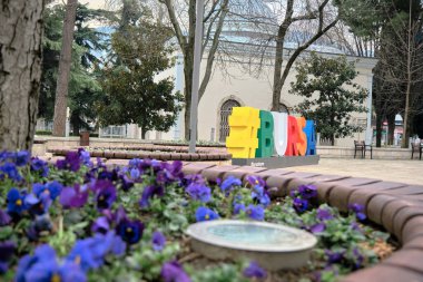 Bursa, Türkiye 29.03.2021. Bulutlu ve bulutlu bir günde hashtag sembollü renkli BURSA ile Bursa tophane Meydanı. Uulu dağı (uludag) arka planına sahip klasik tip kırmızı telpher kabini.