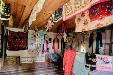 Gelin için geleneksel Türk kıyafetleri eski mahsul ve ahşap malzemeden yapılmış köy evinin içinde düğün porsiyonu olarak.