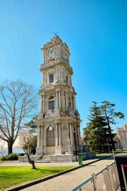 Güneşli bir günde, İstanbul Boğaz Denizi 'nin yanındaki Dolmabahce Sarayı' nın önündeki eski ve eski bir şilte mimarisi ve stil saat kulesi. 03.03.2021 İstanbul Türkiye.
