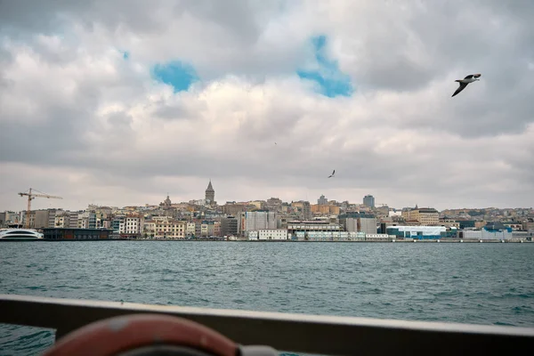 04.03.2021 İstanbul hindisi. İstanbul 'daki Galata Kulesi' nin altın boynuzu bulutlu hava ve bulutlu gökyüzünde martı varken İstanbul 'da iç taşımacılık için yaya feribotundan fotoğraf çekerek..
