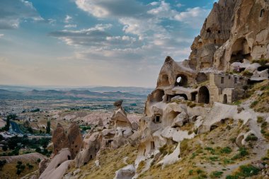 Taştaki volkanik kalıntıların doğal oluşumu ve kapadokya 'daki muhteşem gökyüzü arka planına sahip insan iç kalesinden (uchisar) oluşan mağara.