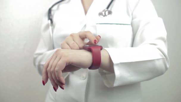 Kobieta lekarz za pomocą inteligentnego zegarek w płaszczyźnie — Wideo stockowe