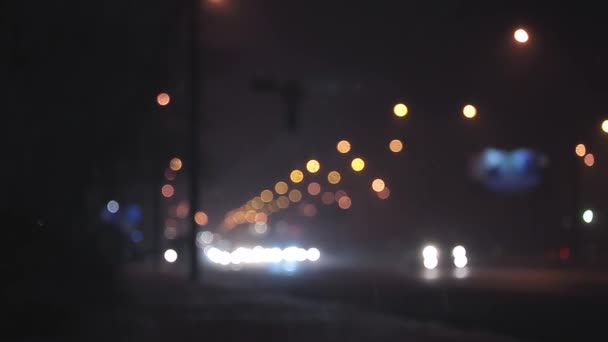 Lluvia desenfocada tráfico nocturno en la ciudad — Vídeo de stock