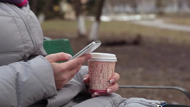 Woman with coffee typing text message on mobile phone — Stock Video