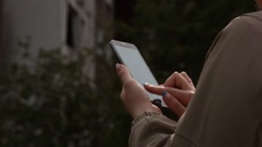 Akıllı telefon kullanan genç bir kadın.